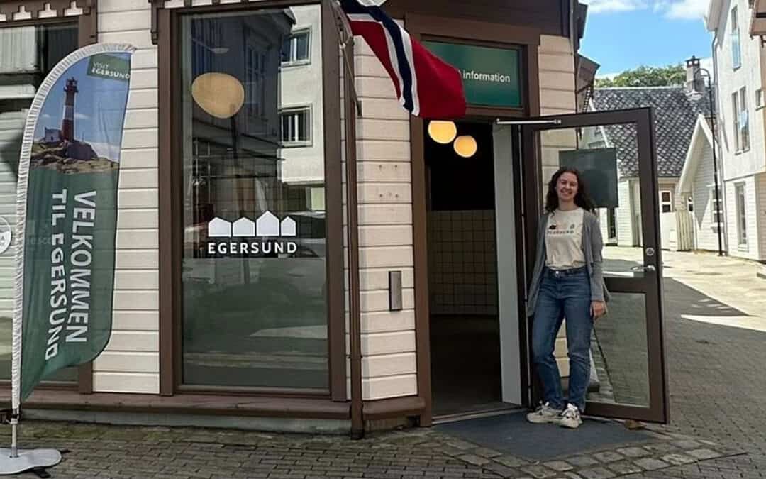 En turistvert som står utenfor turistinformasjonen og ønsker velkommen